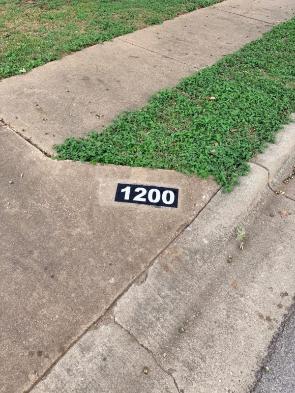 Freshly painted curb address marker in Cedar Park, TX